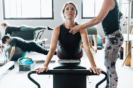 woman on a reformer doing sawn dive