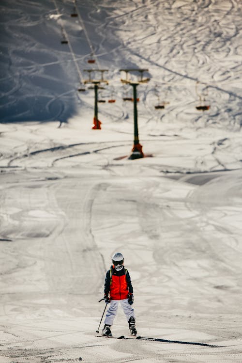 Person at the bottom of a ski hill with skis on