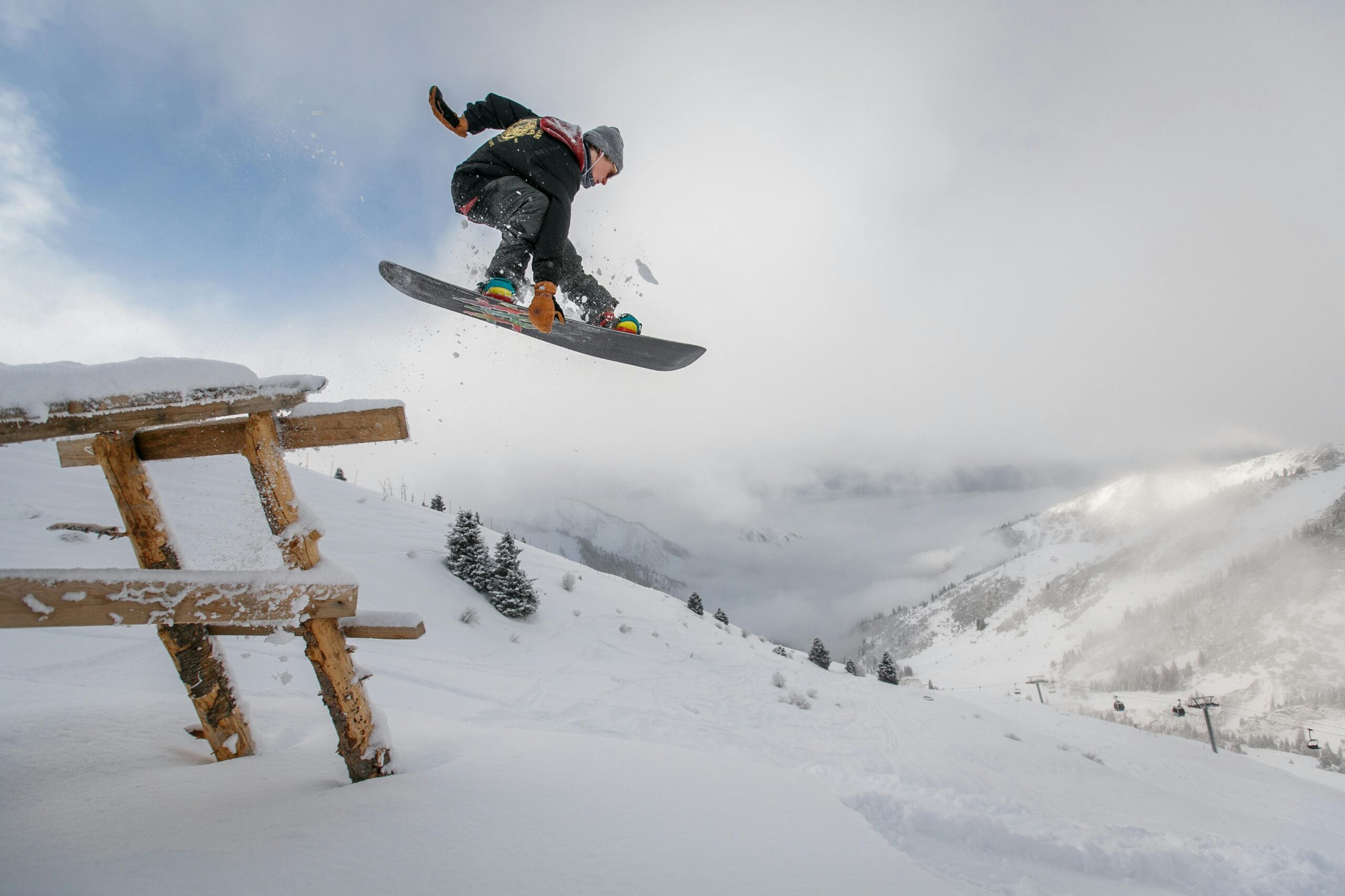 snow boarder jumping over picnic table
