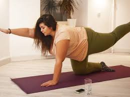 overweight womeone in yellow tshirt doing bird dog